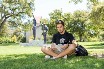 Student studying on Carlos lawn 